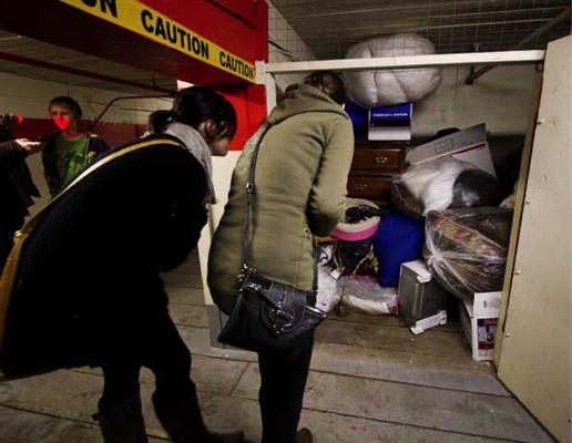 Bidders check out the contents of a storage locker being auctioned on Thursday Nov. 17, 2011, in Victoria. The lockers have been left unpaid for more than six months and U-Haul wants them emptied so it can rent the space to someone else.